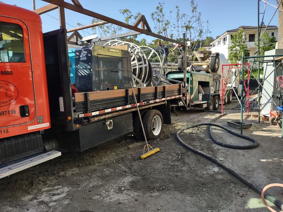 Construction site with heavy machinery, trucks, and equipment on a sunny day.