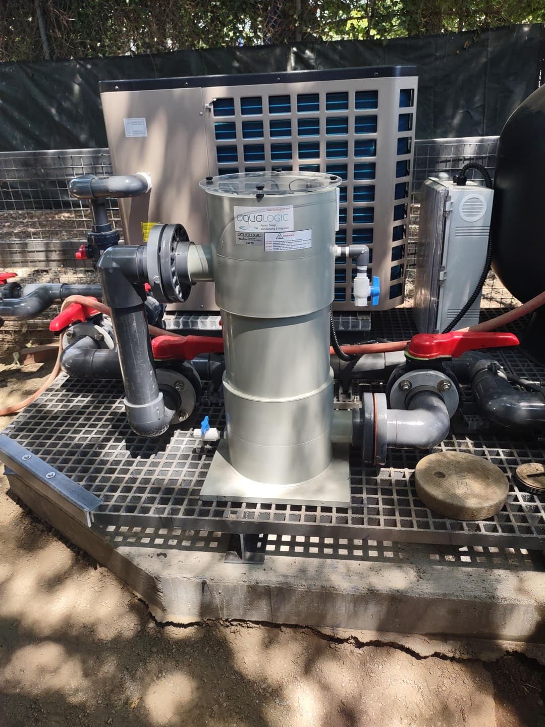 Water filtration system with pipes and connections in outdoor setup. Efficient water management.